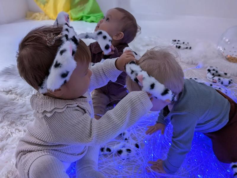 Tre små børn leget på et tæppe